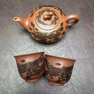 Handcrafted teapot with painted dragon pattern that changes color when hot water is added; includes matching tea cup.H019