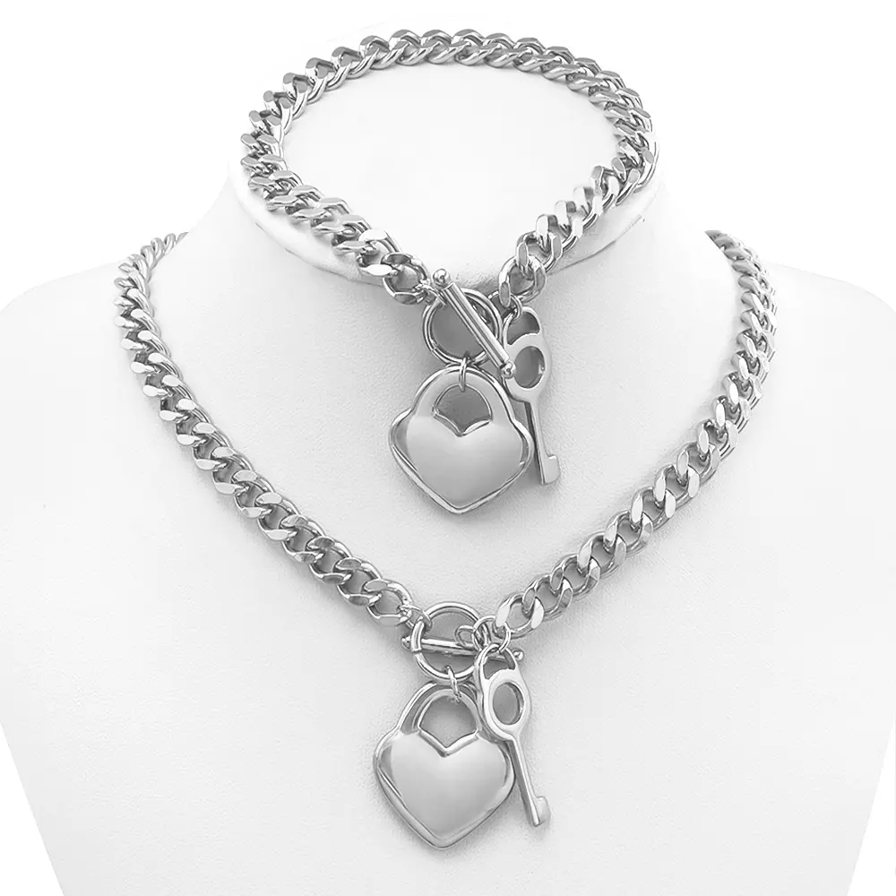 Colorfast silver-tone Cuban chain set with heart lock and key charm; waterproof stainless steel necklace and bracelet two-piece set for everyday stacking.