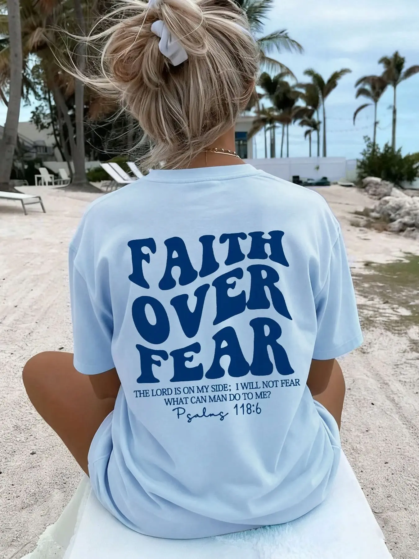 Women's summer oversized baggy printed T-shirt with the Bible verse "Faith overcomes fear" printed on it. This casual, loose-fitting short-sleeved top is perfect for summer beach wear and everyday casual wear.
