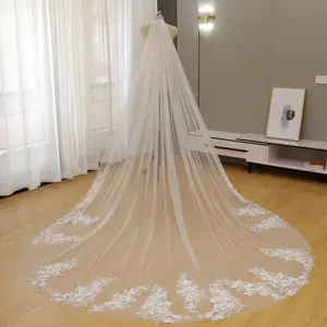 A bridal veil featuring 3D floral embellishments with embedded flowers and diamonds along the edge of the train.