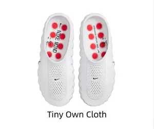 All-white perforated slip-on foam slides with chunky wavy sole & red anti-slip outsole studs