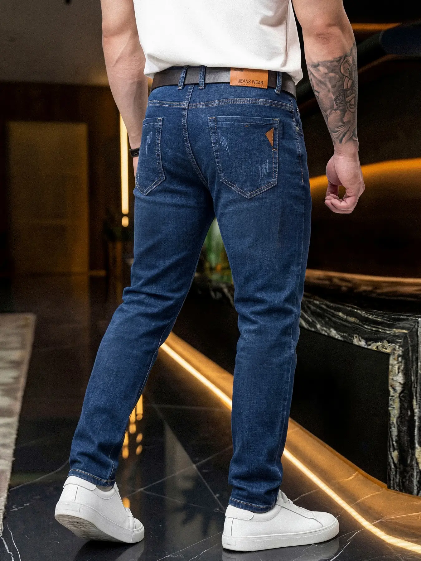 Men's slim-fit straight-leg Denim jeans in blue with micro-elasticity, featuring a sharp and smooth silhouette, adorned with a leather label on the back pocket for added sophistication, suitable for various semi-formal occasions.