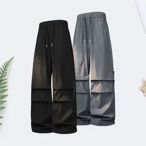 Men’s loose cargo pants with elastic waistband, casual streetwear style, parachute-style design, equipped with zippered pockets