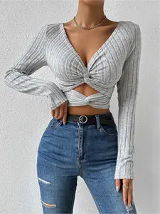 Women's minimalist long-sleeve fitted top in solid color, featuring a knot and cut-out design. Ideal for versatile daily casual wear.