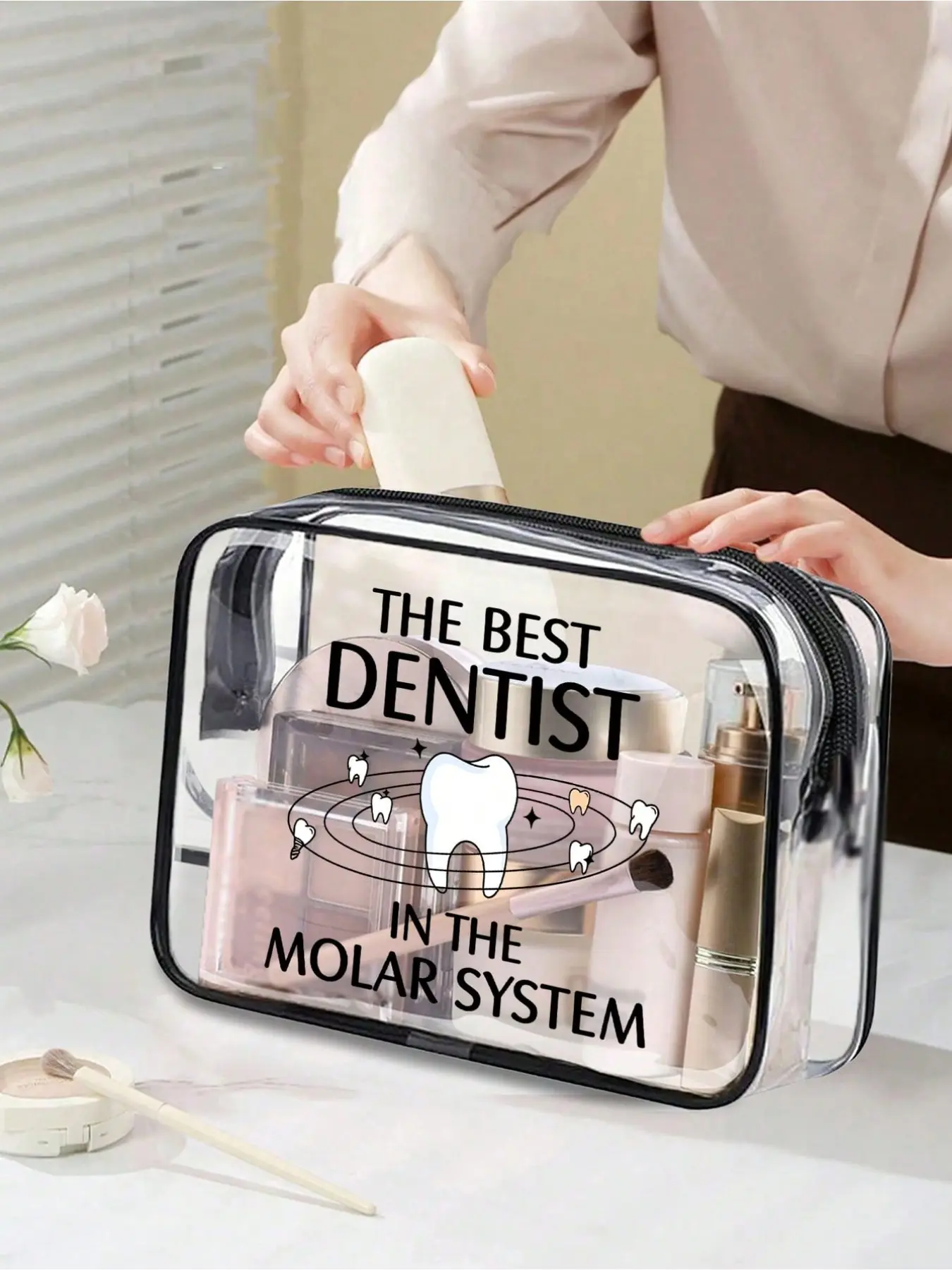 Clear PVC cosmetic bag with fun "Galaxy's Best Dentist" print. Waterproof and portable with zipper. Ideal for dentists, dental students and oral care lovers for work, travel and beach use.