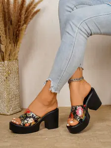 A pair of floral print platform wedge mules with a wide strap and chunky heel, featuring a vibrant floral pattern and open toe, perfect for casual dates and evening outings, adds a pop of color to flowy dresses and jeans.
