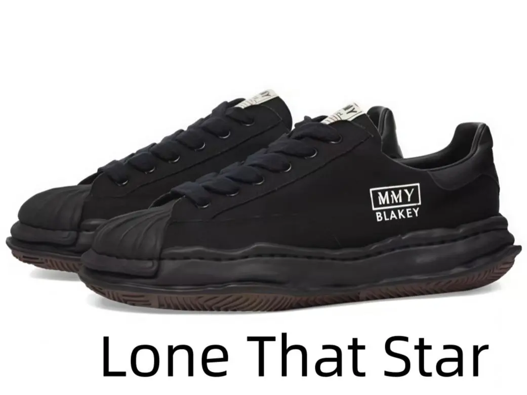 Bold black lace-up dad-style sneakers with distinctive undulating sculpted midsole, hard-shell toe cap, easily pair with oversized hoodies, denim jeans and every dark minimalist street fashion aesthetic