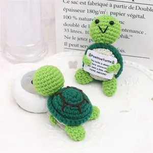 An adorable, handmade knitted wool turtle—complete with an inspirational message card—serving as a warm and soft desktop ornament.