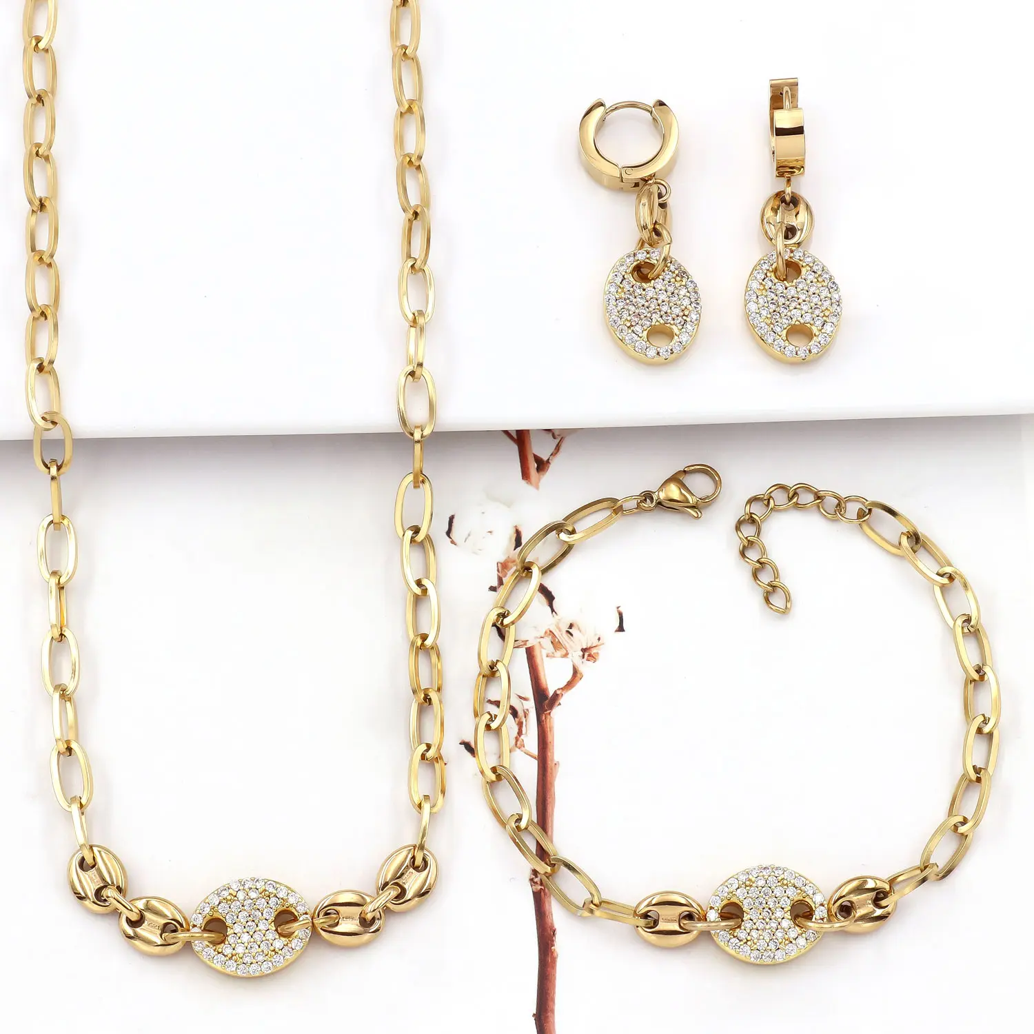 Set of three items that resists color fading: a bright gold paper clip chain with fully set stones and a round disc design; waterproof stainless steel necklace, bracelet, and earrings—versatile for everyday stacking.