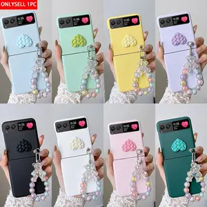 Candy-colored heart-shaped phone case with a small bear pendant bracelet. The hard PC back plate protects the phone. Compatible with Motorola Razr 2023/Razr 40