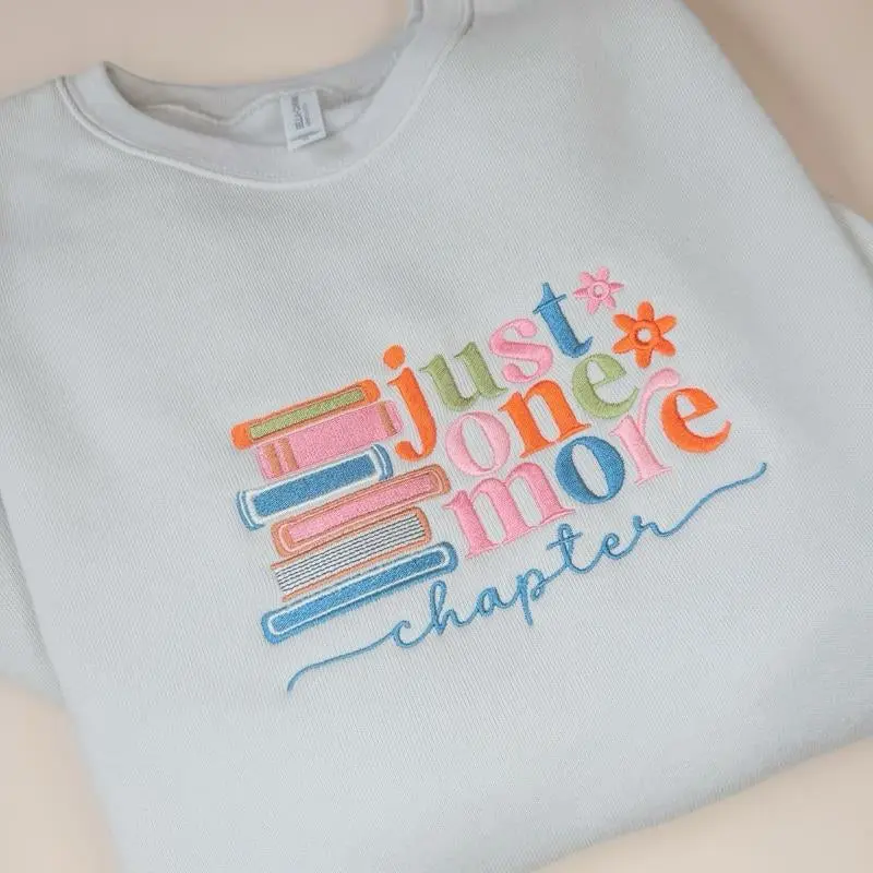Just One More Chapter Sweater - White Pullover with Colorful Book Design and "Chapter" Text - Womenswear
