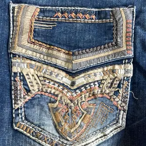 SA039 Dark Blue Denim Jeans with Intricate Embroidery and Gold Accents for Men