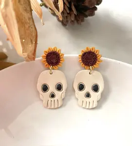 Handmade polymer clay skull earrings. Skull hangs from a fall flower attached to a hypoallergenic stud. Perfect for some spooky fun for the fall season and Halloween festivities.
