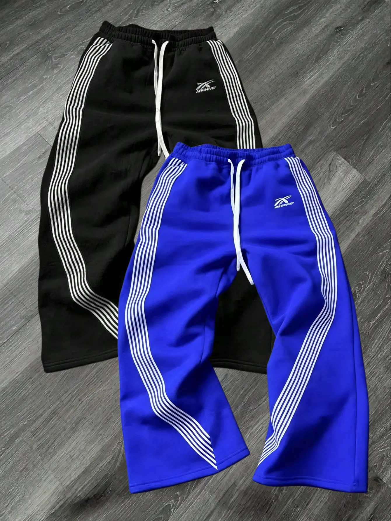 Men’s two-pack wide-leg sweatpants with curved side stripes, elastic drawstring waist, letter print, skin-friendly and comfortable, suitable for hip-hop, street style, and everyday wear.