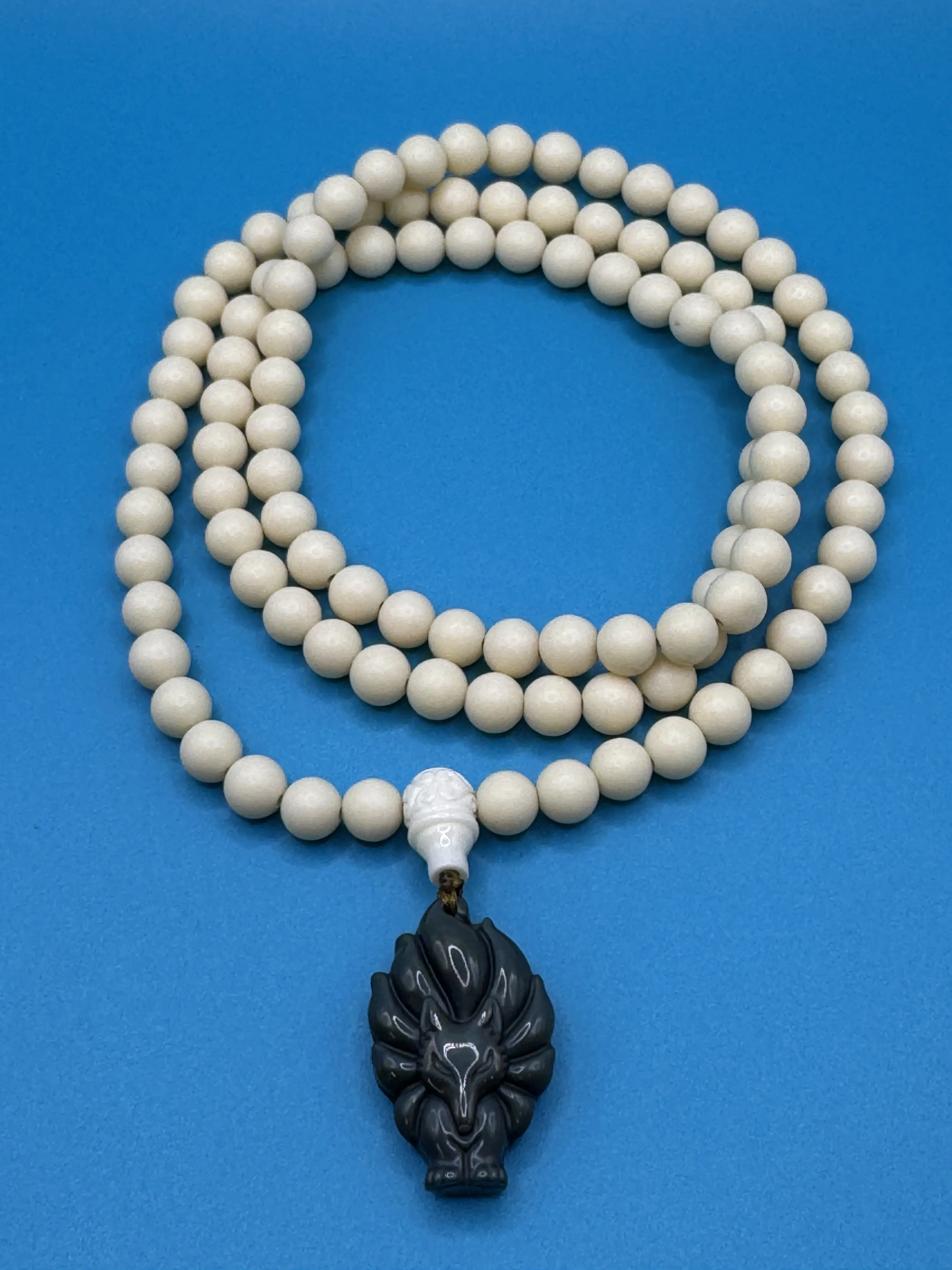 9 tail rainbow obsidian fox pendant on an ivory nut necklace.