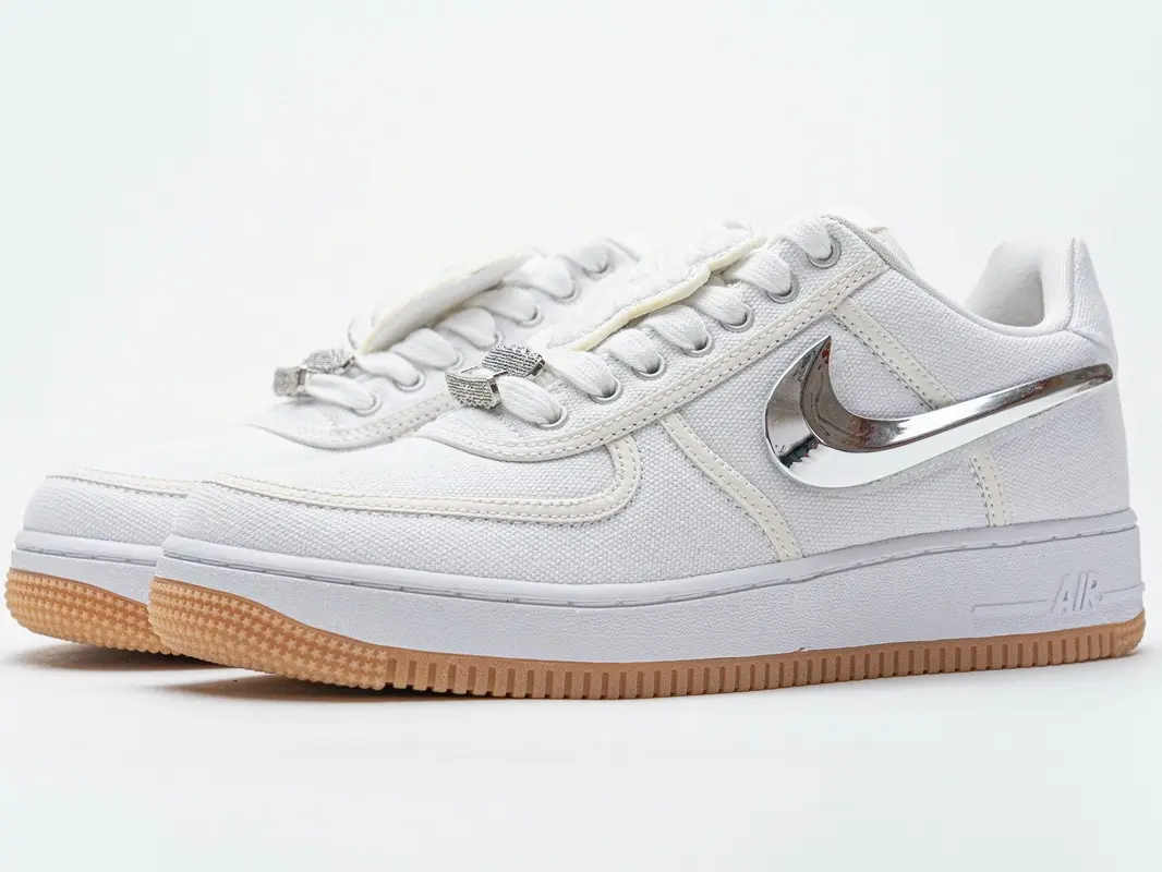 White low‑top canvas casual sneakers with metallic silver side ornaments, metal shoelace accessories and caramel‑colored textured rubber outsoles