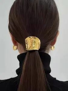 High-end hair clips, hair ornaments with a glossy metallic finish and textured lava pattern, and low ponytail clips at the back of the head.