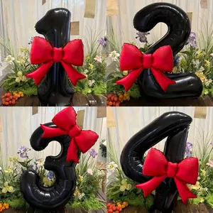 A set of large black number balloons, ranging from 0 to 9, decorated with red bows and made of foil material.  Perfect for decorating birthday parties, gatherings, anniversaries, holidays, outdoor events, and adding atmosphere to photos.