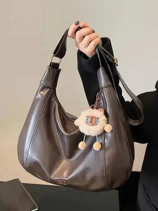 Simple retro distressed shoulder handbag, cute plush pendant shoulder bag, personalized creative crescent bag, casual and fashionable all-match large bag, niche design suitable for daily commuting, shopping, etc. Work