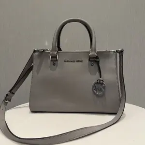 Pre-owned MICHAEL KORS MK gray shoulder bag, can be carried by hand or worn on one shoulder, with shoulder straps included.