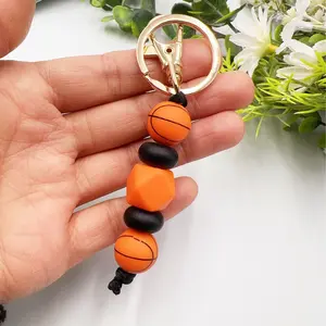 Sports-themed silicone beaded keychains for soccer, basketball, rugby balls, bags, and accessories.