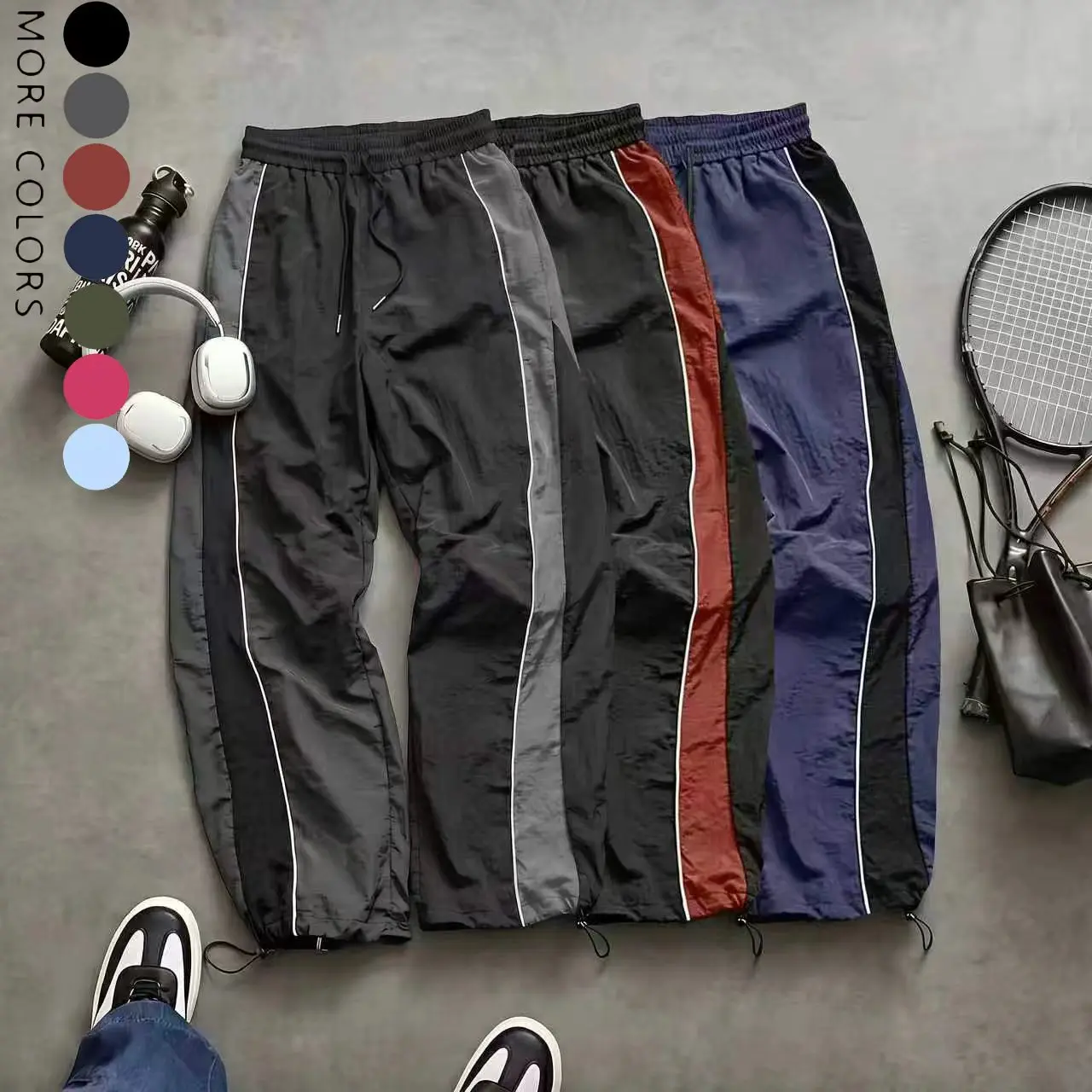Men’s high-street style wide-leg pants with contrast color panels, side stripes, and a drawstring; American retro loose, drapey athletic pants; available in multiple colors; slim casual pants suitable for spring and summer wear.