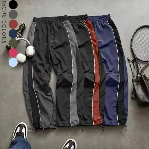 Men’s high-street style wide-leg pants with contrast color panels, side stripes, and a drawstring; American retro loose, drapey athletic pants; available in multiple colors; slim casual pants suitable for spring and summer wear.