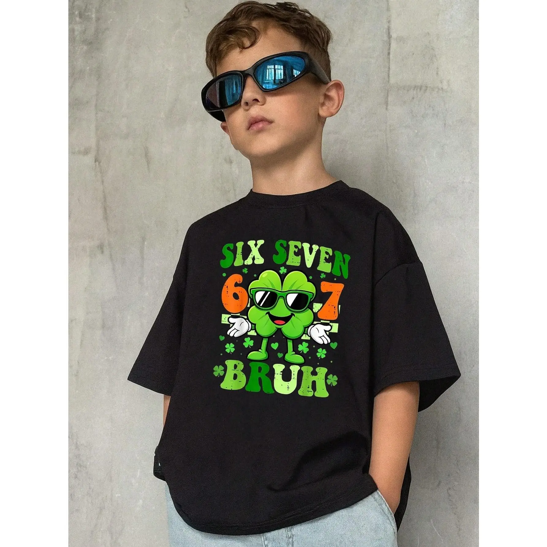 Kids' St. Patrick'S Day Graphic Tee, Boys & Girls Irish Luck Birthday Party Shirt  shamrock character wearing sunglasses and holding up peace signs. The design includes the phrase "SIX SEVEN BRUH"Casual Top for St. Paddy'S Day Celebrations
