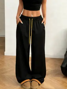 Streetwear Y2K hot‑girl high‑waisted drawstring wide‑leg pants with a bent‑blade silhouette that perfectly sculpts the leg line; color‑blocking with contrast drawstrings and small metal logo accents; color‑blocked cuffs; American street/wasteland style—of