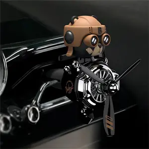 New car air freshener in the shape of a small airplane with a black bear that shakes its head, diffuses fragrance through the air vents, and rotates to release scent inside the car