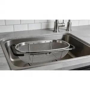 Expandable stainless steel over-sink colander with fine mesh and non-slip rubber grip. Practical large kitchen tool for straining and draining, ideal for daily kitchen use.  SURE