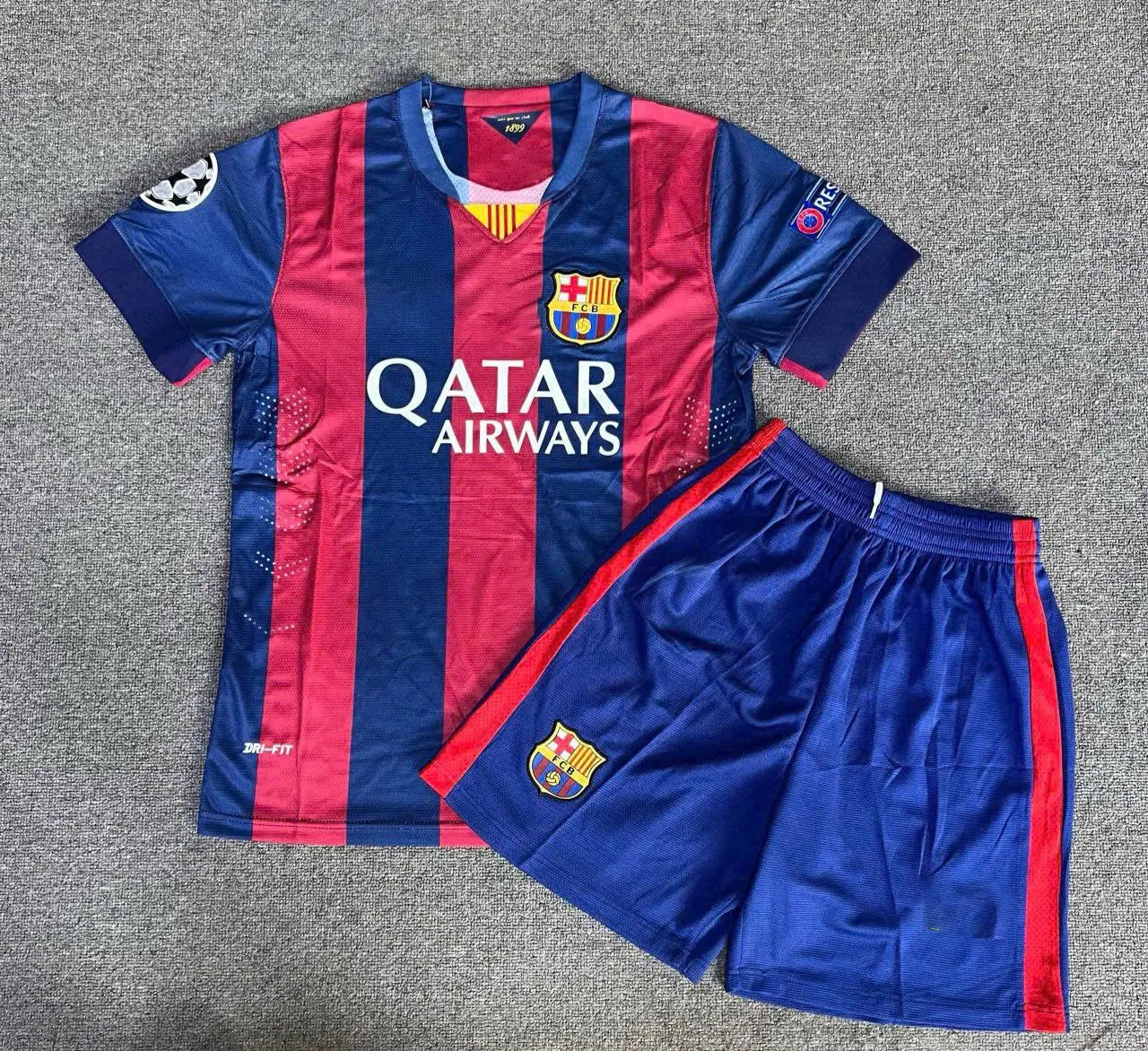 Barcelona Striped Soccer Jersey Set Grey Carpet Flat Lay Display | Breathable Short Sleeve Kit Shorts | UEFA Champions League Fan Gear Apparel Gift