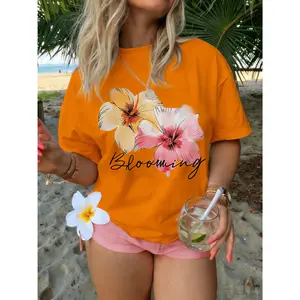100% cotton women's plus-size loose-fitting white T-shirt, featuring a stylish design with two beautiful yellow-orange and pink flowers printed on it, paired with the elegant cursive text "Blooming". It is soft, comfortable, lightweight, and breathable