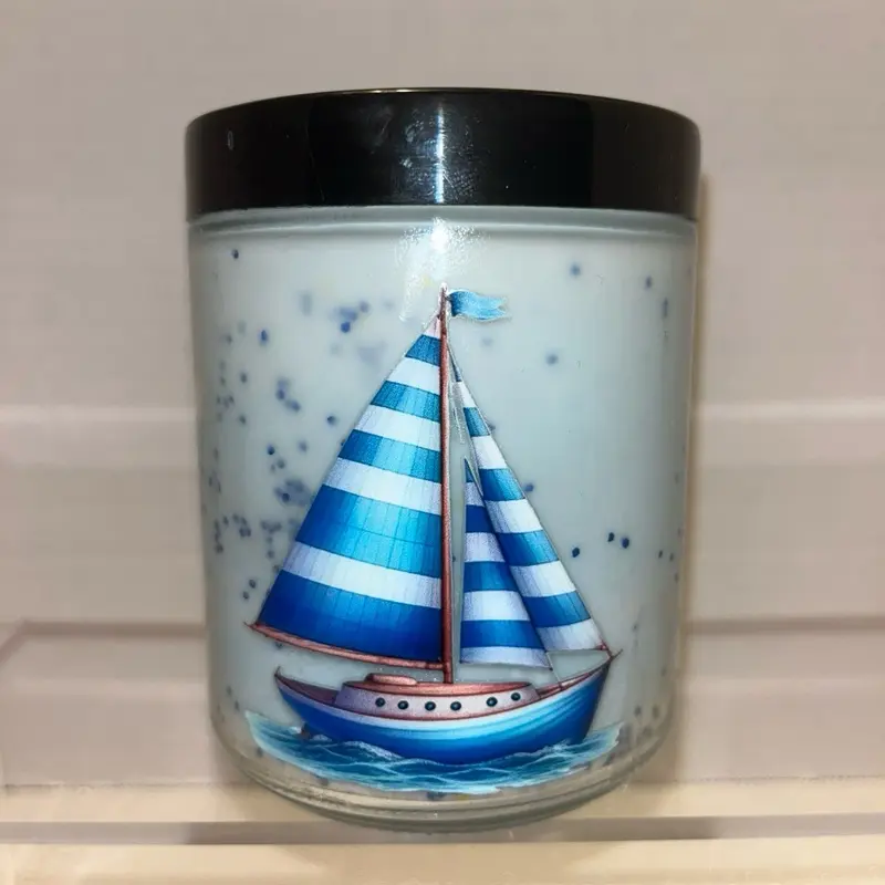 Sailboat Design Candle in Clear Glass with Black Lid, Blue and White Striped Sails, Ideal for Home Decor