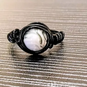 handmade black wire wrapped ring with green   white and black swirl stone size 7