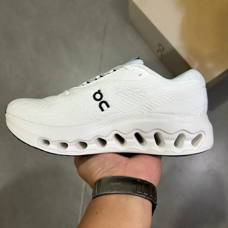 Solid white monochrome hollow cushioned low-top running trainers featuring scuff-proof pale rubber outsoles, tear-resistant sweat-wicking stretch knit mesh construction, mesh embedded airflow cutouts, full wavy hollow lightweight foam midsole layout