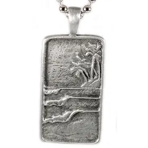 The Surf Tag Necklace by Strickly Boarding and Joe Paradise.  Elegant Handmade Jewelry for Ocean Lovers Unique Surfing Accessory with perfect waves under a tropical backdrop.