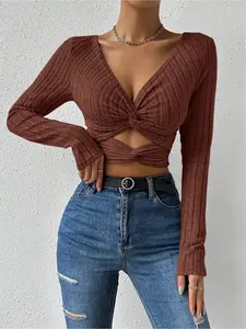 Women's minimalist long-sleeve fitted top in solid color, featuring a knot and cut-out design. Ideal for versatile daily casual wear.