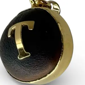 Dije de ojo de buey con las iniciales T-L-E