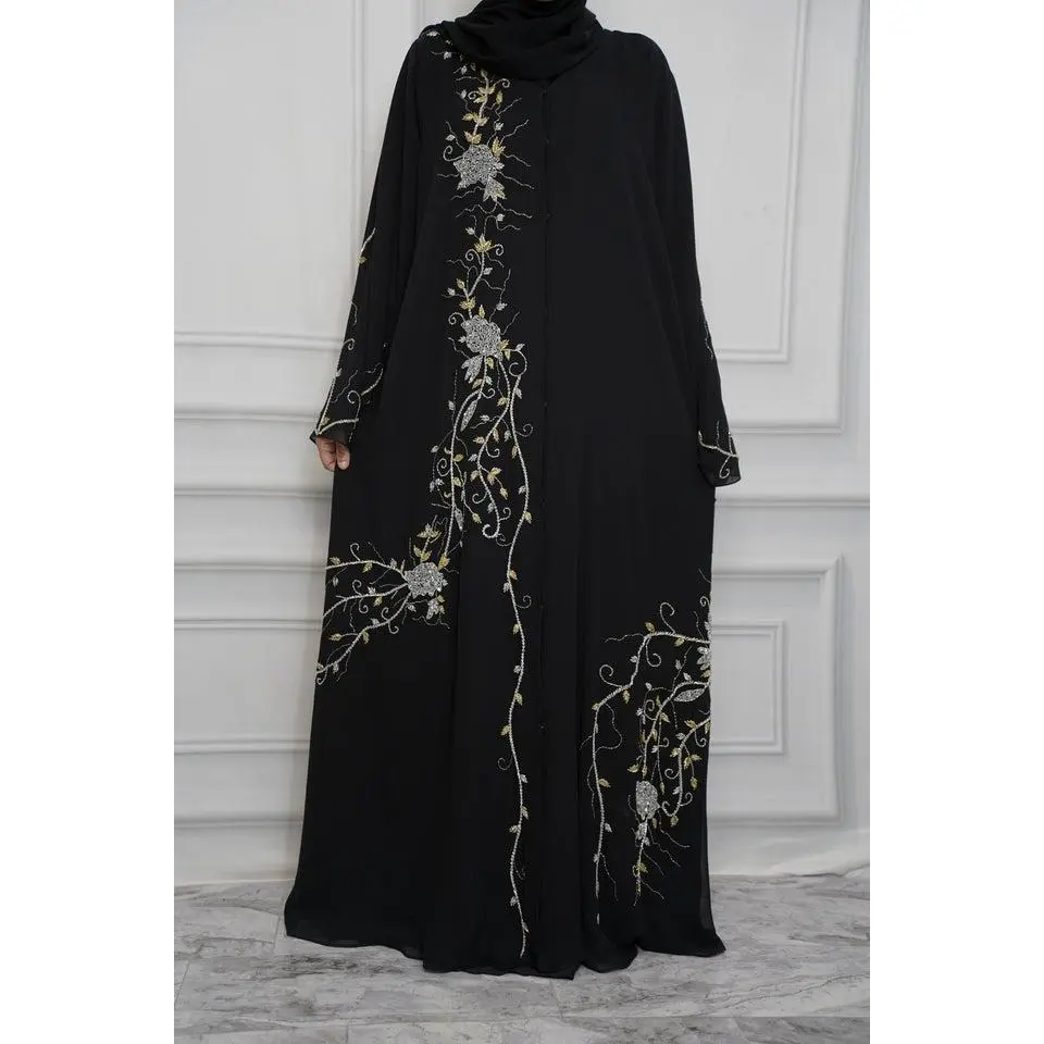 The Amal Abaya is a handcrafted piece with intricate front and back detailing. Gold and silver floral vines flow from the shoulders down, creating an elegant, elongated look. The design continues seamlessly onto the back for a full, cohesive finish.
