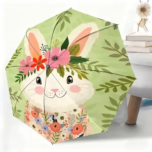 A waterproof folding umbrella featuring a white rabbit wearing a flower wreath and floral dress against a background of green leaves. Suitable for both men and women, it is portable and ideal for travel and everyday use.