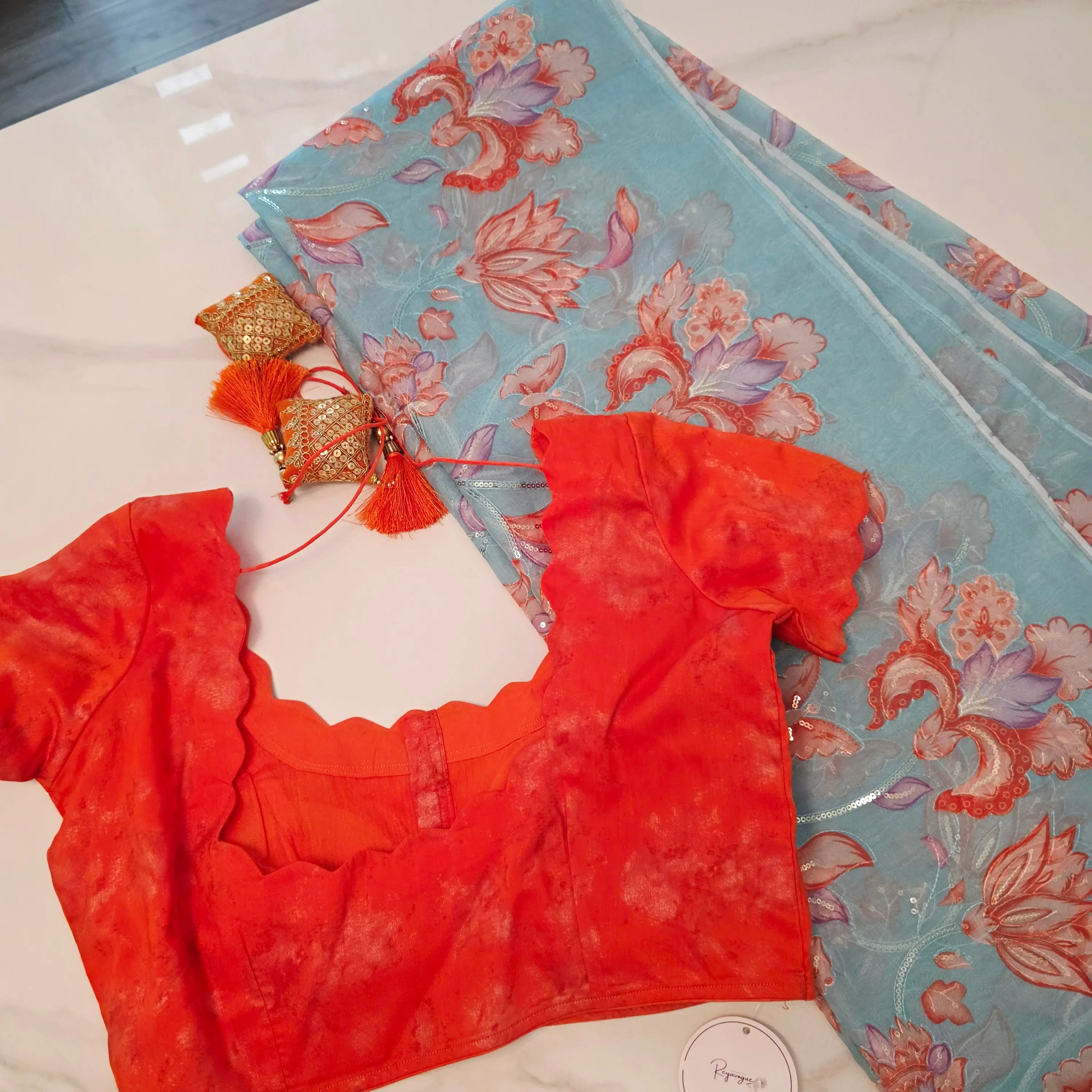Reyavogue Women's Skyblue Organza Saree with floral sequins all over paired with bright orange blouse