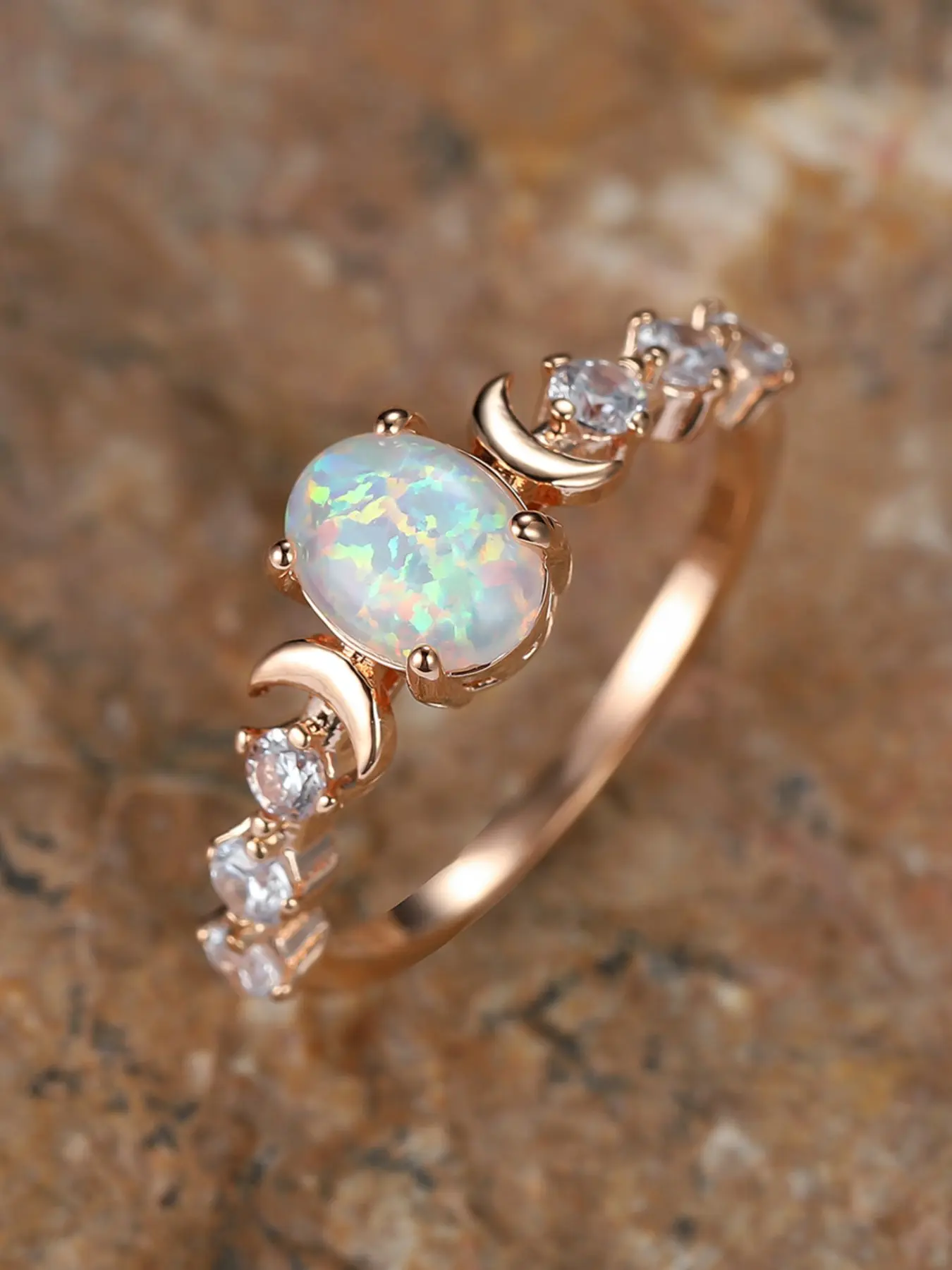 A stylish, commuting, champagne-gold, four-claw, oval-shaped, white, synthetic opal ring with a moon-shaped edge Aurora Ring Jewelry Rings