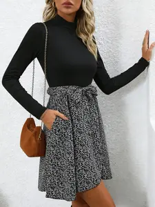A fashionable women's black and white spliced high neck long sleeve dress with layered design and a high waisted tie for commuting, shopping, and outdoor wear