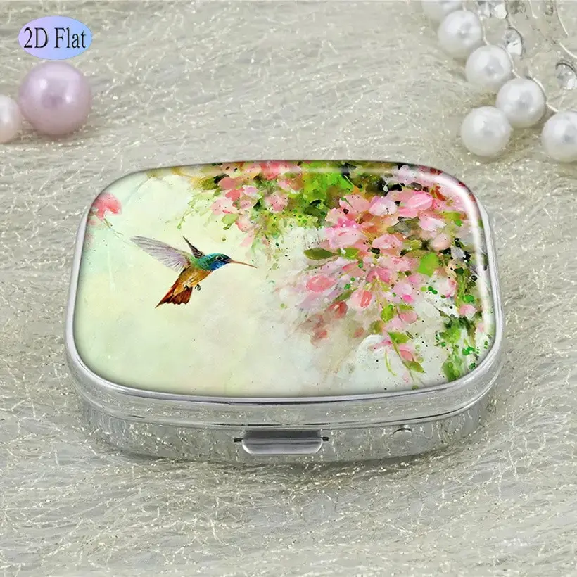 Pocket-Sized Pill Organizer with Two Compartments, Featuring a Decorative Design of a Charming Hummingbird And Pink Flowers, Perfect for Travel And As a Gift