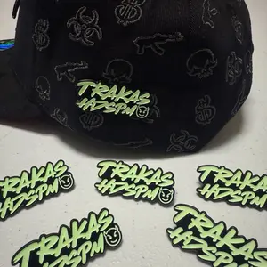 Trakas Pin Metálico - Black Item with Green Trakas Logo and Skull Patterns