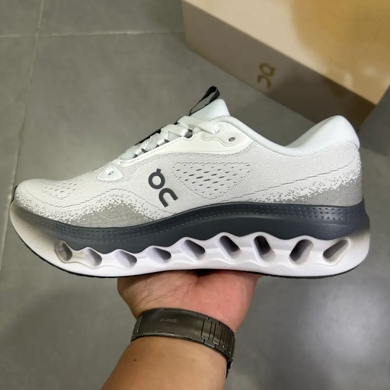 Off-white dark grey accented hollow cushioned low-top running trainers featuring scuff-proof pale rubber outsoles, tear-resistant sweat-wicking stretch knit mesh construction, mesh embedded airflow cutouts, segmented hollow lightweight foam midsole layout