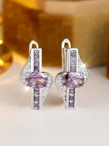 A pair of oval-shaped synthetic red crystal earrings, stylish and vintage-inspired, in silver color, suitable for women to wear as everyday earrings for special occasions like weddings.