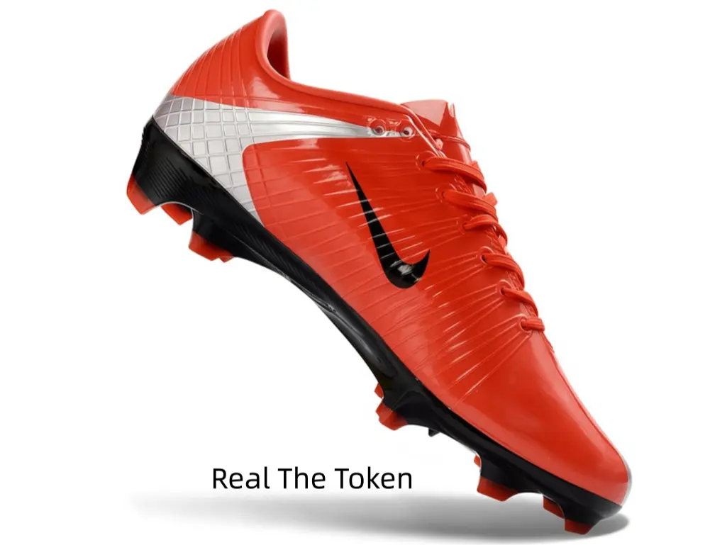 Streamlined turf soccer footwear with reflective glossy red surface, thin upper delivers sensitive touch for precise passes, molded red studs ease foot fatigue over long training sessions.