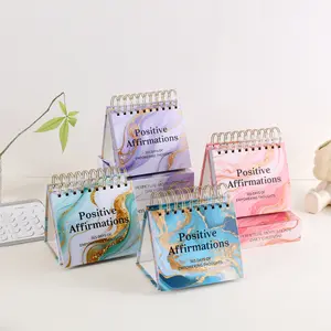 One Piece of a Desktop Calendar Featuring Empowering Thoughts And Positive Affirmations for Every Day of The Year. It Has a Standing Flip Design with Inspirational Quotes And Colorful Inner Pages, Making It Suitable for Use at School, Home